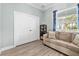 Bright living room features wood-look floors, neutral walls, and large window creating a comfortable and inviting space at 716 Laurel Ave, Venice, FL 34285