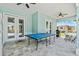 A covered patio features a ceiling fan and a ping pong table for outdoor entertaining at 716 Laurel Ave, Venice, FL 34285
