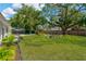 Spacious backyard featuring mature shade trees, a firepit, and seating area at 7210 S Sparkman St, Tampa, FL 33616