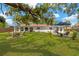 Spacious backyard featuring mature trees, lush green grass, a fire pit and patio area, and an outdoor seating at 7210 S Sparkman St, Tampa, FL 33616