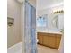 Well-lit bathroom featuring a shower/tub combo and a modern vanity, brushed gold fixtures at 7210 S Sparkman St, Tampa, FL 33616