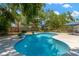 Beautiful in-ground pool with blue tile, concrete pool deck, and mature shade trees at 7210 S Sparkman St, Tampa, FL 33616