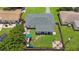 An aerial view of the backyard featuring a playground, fire pit, and lush green lawn at 8339 75Th Ave, Seminole, FL 33777