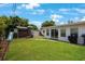 Backyard featuring a playset, lush green lawn, and glass sliding doors at 8339 75Th Ave, Seminole, FL 33777