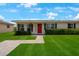 Charming single story home with a bright red door and lush green lawn at 8339 75Th Ave, Seminole, FL 33777