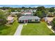 Charming single-story home featuring a red front door, green lawn, and meticulously manicured landscaping at 8339 75Th Ave, Seminole, FL 33777