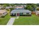 Charming single-story home featuring a red front door, green lawn, and meticulously manicured landscaping at 8339 75Th Ave, Seminole, FL 33777