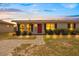 Inviting single-story home featuring landscape lighting, a red front door, and welcoming stone walkway at 8339 75Th Ave, Seminole, FL 33777