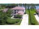 Stunning aerial view of estate home with a red tile roof, lush landscaping, and lake access at 9827 Sorbonne Loop, Seffner, FL 33584