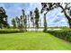 Expansive backyard with lush green grass, mature trees, and lake view at 9827 Sorbonne Loop, Seffner, FL 33584