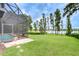 Wide backyard with manicured lawn, mature trees, and view of the lake at 9827 Sorbonne Loop, Seffner, FL 33584