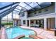 Large in-ground pool with a brick surround and a covered patio area at 9827 Sorbonne Loop, Seffner, FL 33584