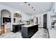 Modern kitchen with black island, granite countertops, and stylish pendant lighting at 9827 Sorbonne Loop, Seffner, FL 33584