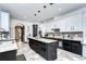 Modern kitchen with a center island, dark cabinets, and sleek finishes creates a functional and stylish cooking space at 9827 Sorbonne Loop, Seffner, FL 33584