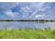 Scenic lake view with blue skies, clouds, and natural vegetation along the shoreline at 9827 Sorbonne Loop, Seffner, FL 33584