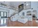 Open-concept living room with high ceilings, wrought iron staircase, and hardwood floors, perfect for entertaining at 9827 Sorbonne Loop, Seffner, FL 33584