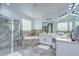 Bright main bathroom with a glass shower, soaking tub, and dual sinks at 9827 Sorbonne Loop, Seffner, FL 33584