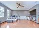 Large main bedroom with hardwood floors, bay windows, ceiling fan, and comfortable furnishings at 9827 Sorbonne Loop, Seffner, FL 33584