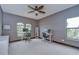 Bright office space with carpet, large windows, dual workstations, and ceiling fan at 9827 Sorbonne Loop, Seffner, FL 33584