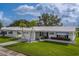Inviting one-story home featuring a white exterior, integrated garage, and vibrant flower beds, creating a picturesque setting at 10005 41St N St, Pinellas Park, FL 33782