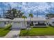 Charming single-story home with white tile roof, well-manicured lawn, and paver driveway, presenting a welcoming curb appeal at 10005 41St N St, Pinellas Park, FL 33782
