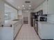 Spacious kitchen featuring white cabinetry, black appliances, tile floor, and natural light at 10005 41St N St, Pinellas Park, FL 33782