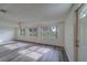 Light-filled living room with large windows, gray floors, and a front door entrance at 10005 41St N St, Pinellas Park, FL 33782