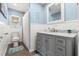 Charming bathroom boasts blue walls, white wainscoting, a marble countertop, and a well-lit vanity at 10339 111Th St, Largo, FL 33778