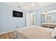 Comfortable bedroom features light-blue walls, a ceiling fan, a TV, and sliding mirror closet doors at 10339 111Th St, Largo, FL 33778