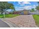 Paver driveway leads to a well-maintained home with mature landscaping and a fenced yard at 10339 111Th St, Largo, FL 33778