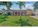 Charming single-story home with vibrant landscaping, mature trees, and a well-manicured green lawn at 10339 111Th St, Largo, FL 33778