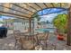 Under the covered patio, enjoy the pool view while seated at the outdoor dining set for four at 10339 111Th St, Largo, FL 33778