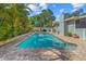 A large pool surrounded by a brick patio and tropical landscaping at 10339 111Th St, Largo, FL 33778