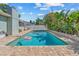 A large pool surrounded by a brick patio and tropical landscaping at 10339 111Th St, Largo, FL 33778