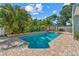 A large pool surrounded by a brick patio and tropical landscaping at 10339 111Th St, Largo, FL 33778