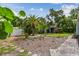 The serene backyard offers tropical landscaping, stepping stones, a storage shed, and inviting atmosphere at 11775 84Th Ave, Seminole, FL 33772