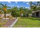 Large backyard with tropical plants, grass, defined mulch beds, shed, and privacy fence at 11775 84Th Ave, Seminole, FL 33772