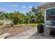 Spacious backyard featuring tropical plants, mulch beds, lawn, shed, patio, and grill at 11775 84Th Ave, Seminole, FL 33772