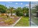 Lush backyard featuring tropical plants, trees, defined mulch beds, and a well-maintained lawn at 11775 84Th Ave, Seminole, FL 33772