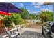 Beautiful backyard with lush tropical landscaping, including a paved area with seating and a grill at 11775 84Th Ave, Seminole, FL 33772