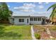Charming home exterior with tropical landscaping in the backyard, patio seating, and a well-maintained lawn at 11775 84Th Ave, Seminole, FL 33772