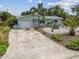 A charming, updated home with a driveway, tropical landscaping, and an inviting entrance at 11775 84Th Ave, Seminole, FL 33772