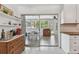 A cozy kitchen showcases a sliding glass door to the sunroom and open shelving with stylish decor at 11775 84Th Ave, Seminole, FL 33772