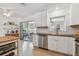 Well-equipped kitchen with stainless appliances, white cabinets, and a view into the bright, sun-drenched dining area at 11775 84Th Ave, Seminole, FL 33772