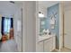 Stylish half-bath with coastal decor, featuring a vanity with a white countertop and blue accent wall at 11785 Little River Way, Parrish, FL 34219