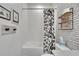 Bathroom featuring a white tiled shower/bathtub, toilet, vanity area with fun wallpaper, and a playful shower curtain at 11785 Little River Way, Parrish, FL 34219