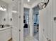 Bathroom with a white single vanity, black fixtures and mirrors; hallway with open door frame and hoop in background at 11785 Little River Way, Parrish, FL 34219