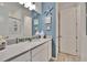 Stylish half-bath with blue accent wall, vanity with white countertop, and nautical decor at 11785 Little River Way, Parrish, FL 34219