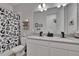 Modern bathroom featuring a double vanity, large mirror, decorative wallpaper, and a whimsical animal-themed shower curtain at 11785 Little River Way, Parrish, FL 34219