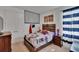 Bright, themed bedroom with a patchwork comforter, wood furniture, comic decorations, and natural light through striped curtains at 11785 Little River Way, Parrish, FL 34219